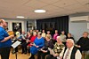 En fullsatt sal i aktivitetshuset på Rørvik, hvor både kormedlemmer og publikum samlet seg til en stemningsfull kveld med sang, glede og fellesskap.