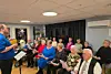 En fullsatt sal i aktivitetshuset på Rørvik, hvor både kormedlemmer og publikum samlet seg til en stemningsfull kveld med sang, glede og fellesskap.