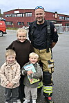 Her er Sandra, Mari, Ivar og brannkonstabel Thomas samlet ute på plassen under den åpne dagen på Rørvik brannstasjon. Ivar holder stolt frem premien de har vunnet i spørrekonkurransen, nemlig 'Brannstigespillet'.