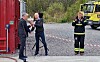 Snorre Eidshaug fra Eidshaug rederi overrekker blomster til daglig leder i Sikkerhetssenteret Bjørn Åge Hestvik på vegne av eierne. Ordfører (eller brannmann) Amund Hellesø applauderer.