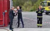 Snorre Eidshaug fra Eidshaug rederi overrekker blomster til daglig leder i Sikkerhetssenteret Bjørn Åge Hestvik på vegne av eierne. Ordfører (eller brannmann) Amund Hellesø applauderer.