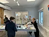 Elever på besøk tester ut roboter og programmering ved Newton-bordet.