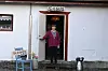 Person i rosa jakke står i døren til et hvitt hus i Sibiu.