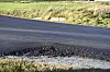 Nylagt mørk asfalt langs veikanten på fylkesvei 770, omgitt av gress.